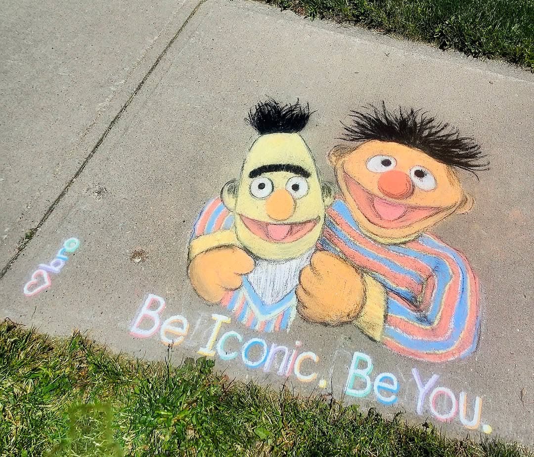 A colourful sidewalk chalk drawing of Bert and Ernie with the words 'Be Iconic. Be You.', by Bronagh Joyce Morgan.