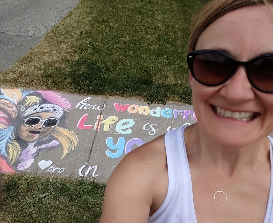 Bronagh Joyce Morgan beside one of her colourful sidewalk chalk murals.